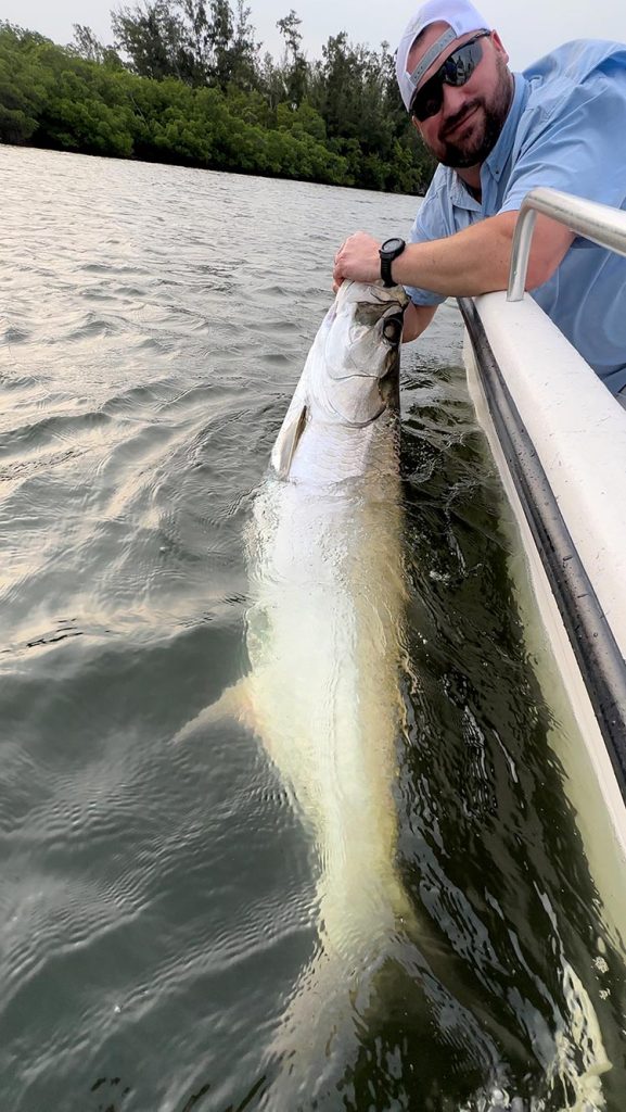 Man holding a mullet in the water